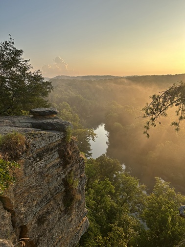 The sun rises over Radnor Lake State Park in Tennessee, lighting the path, kinda like heaping burning coals