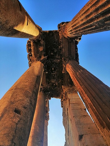 Looking up at four rust-colored Middle Eastern pillars. Could Samson have pulled these down?